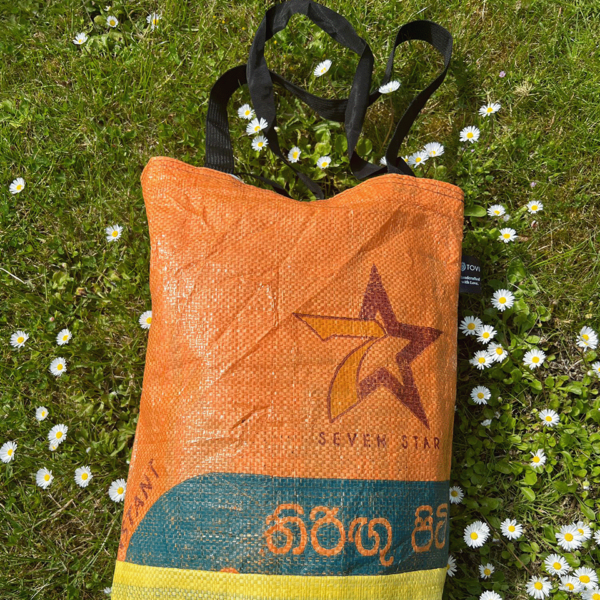 Orange Tote bag from Tovi Gifts lying on green grass